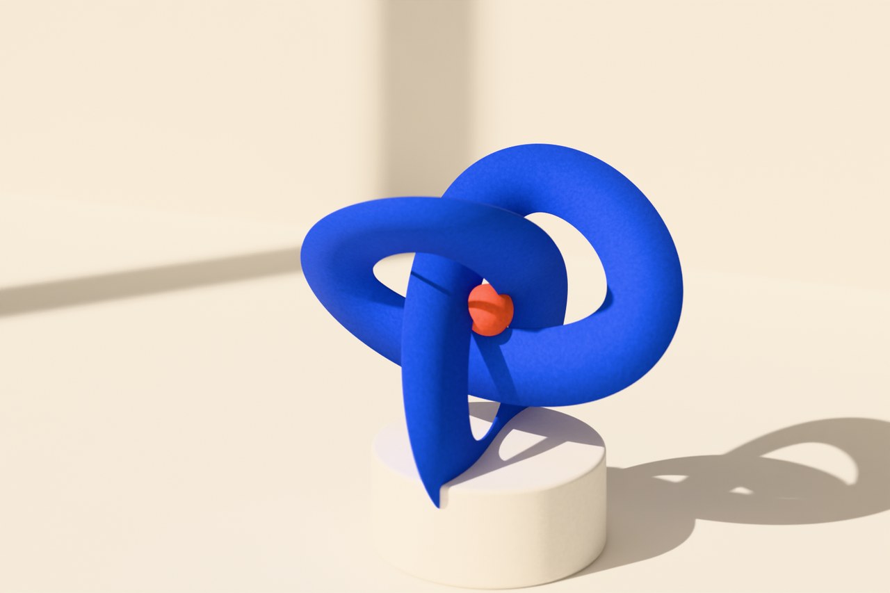 A cobalt paper ribbon folded into a knot on a white plinth, with a small coral bead at its center